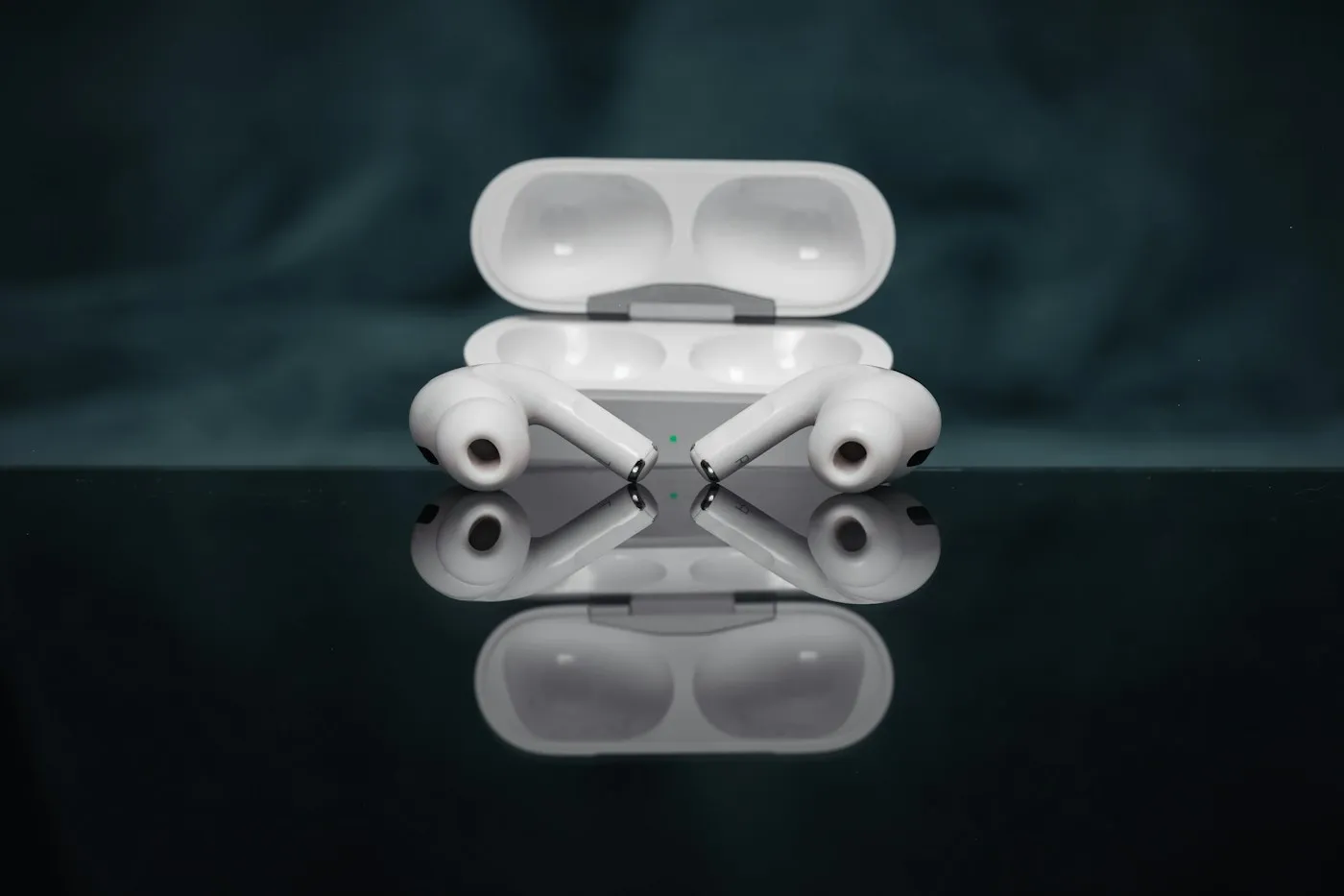 AirPods Pro con su estuche de carga sobre una superficie oscura