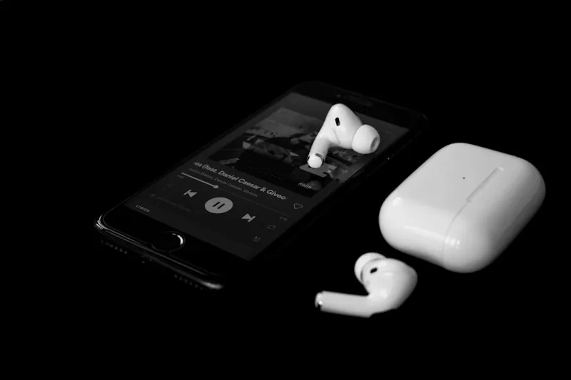 AirPods Pro junto a un iPhone sobre fondo negro