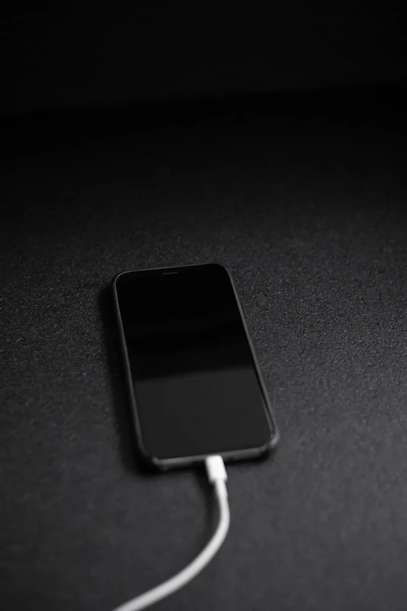 iPhone negro conectado a su cable de carga