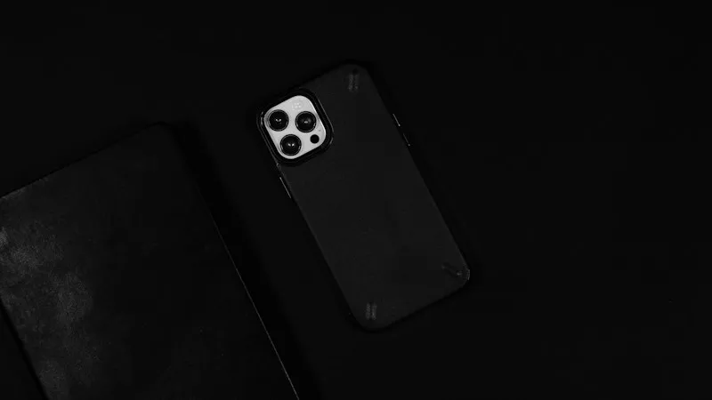 iPhone con funda negra sobre fondo oscuro